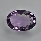 Faceted purple amethyst gemstone on a grey background