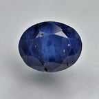Faceted blue sapphire gemstone on a light gray background online India