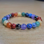Multicolored seven chakra bracelet on a wooden surface
