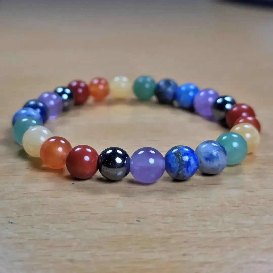 Multicolored seven chakra bracelet on a wooden surface