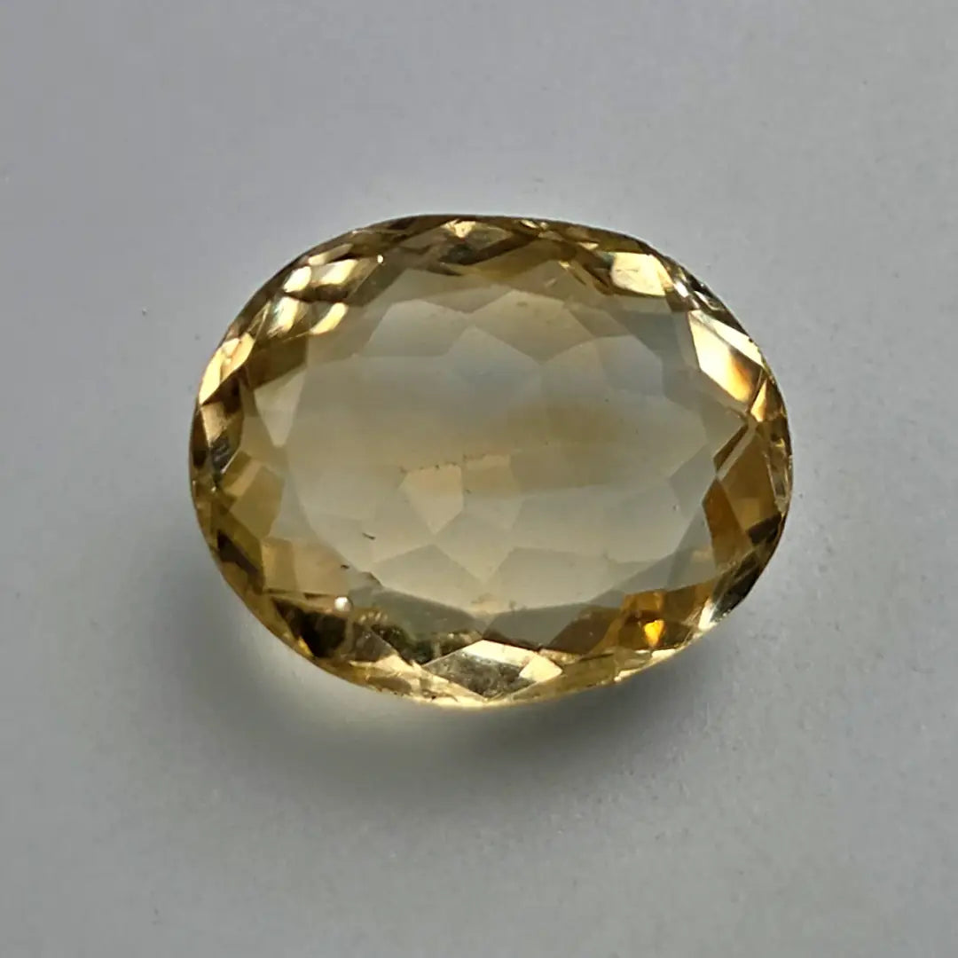 Faceted citrine gemstone on a grey background