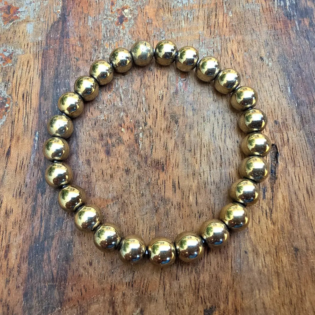 Flat lay of golden pyrite bracelet with natural crystal beads