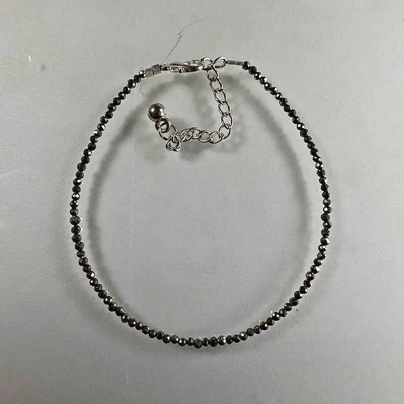 natural stone anklet with black beads on a light grey background