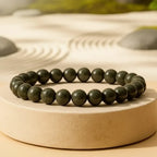 raw pyrite beaded bracelet on a circular stone surface with a natural background