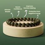 raw pyrite beaded bracelet on a wooden stand with text benefits on a green background