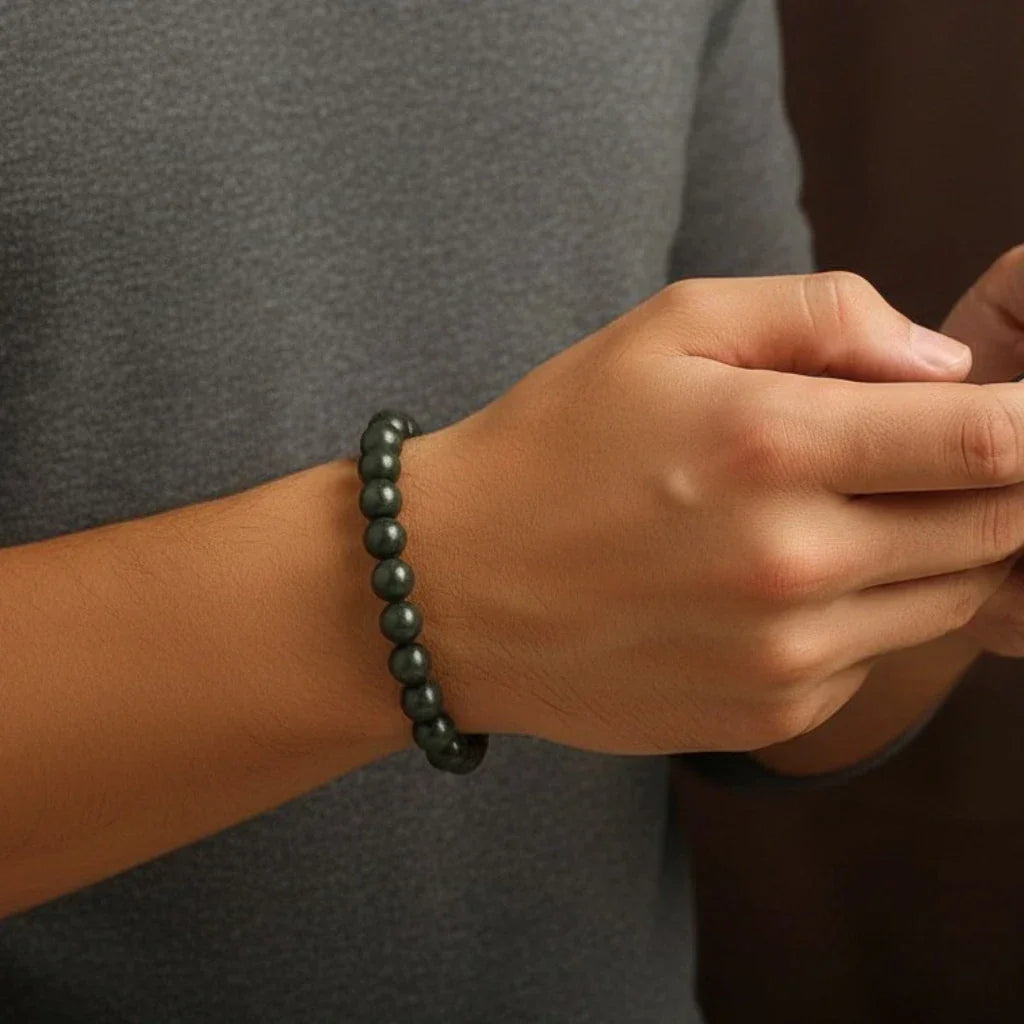 Person wearing a raw pyrite beaded bracelet on a neutral background