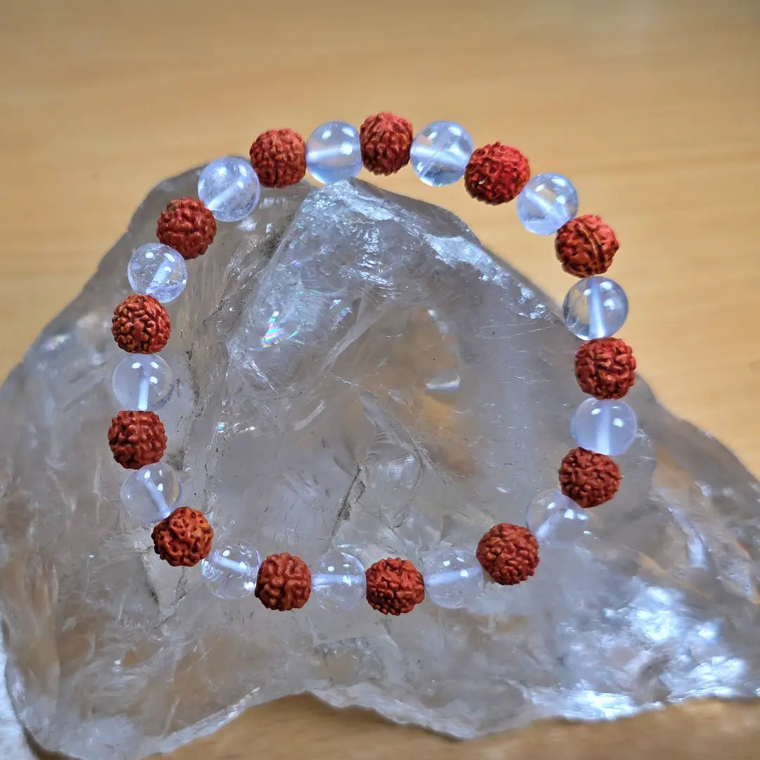 rudraksha crystal bracelet with red and clear beads on a crystal rock