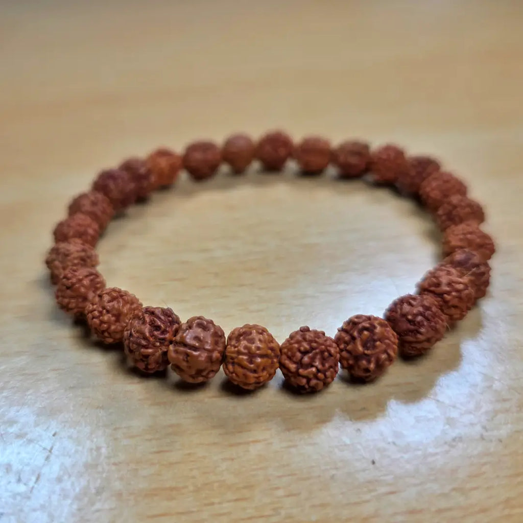 rudraksha bracelet made of brown beads on a wooden surface