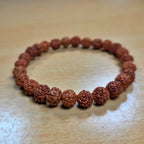 rudraksha bracelet made of brown beads on a wooden surface