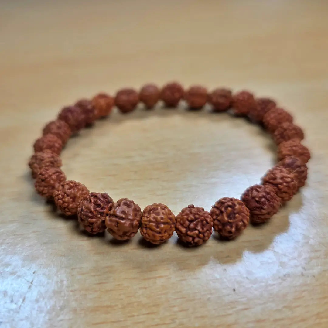 rudraksha bracelet made of brown beads on a wooden surface