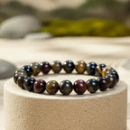 Multicolored tiger eye beaded bracelet on a stone surface with a natural background