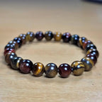 tiger eye bracelet with multicoloured stones on a wooden surface