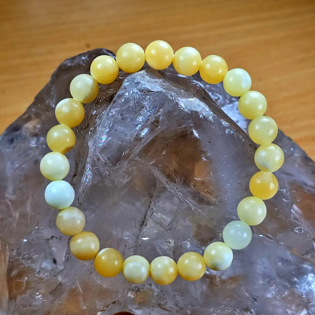 Yellow calcite beaded bracelet displayed on a clear crystal background