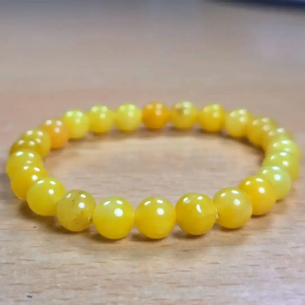 Natural yellow calcite gemstone bracelet showcased on a wooden table