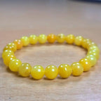 Natural yellow calcite gemstone bracelet showcased on a wooden table